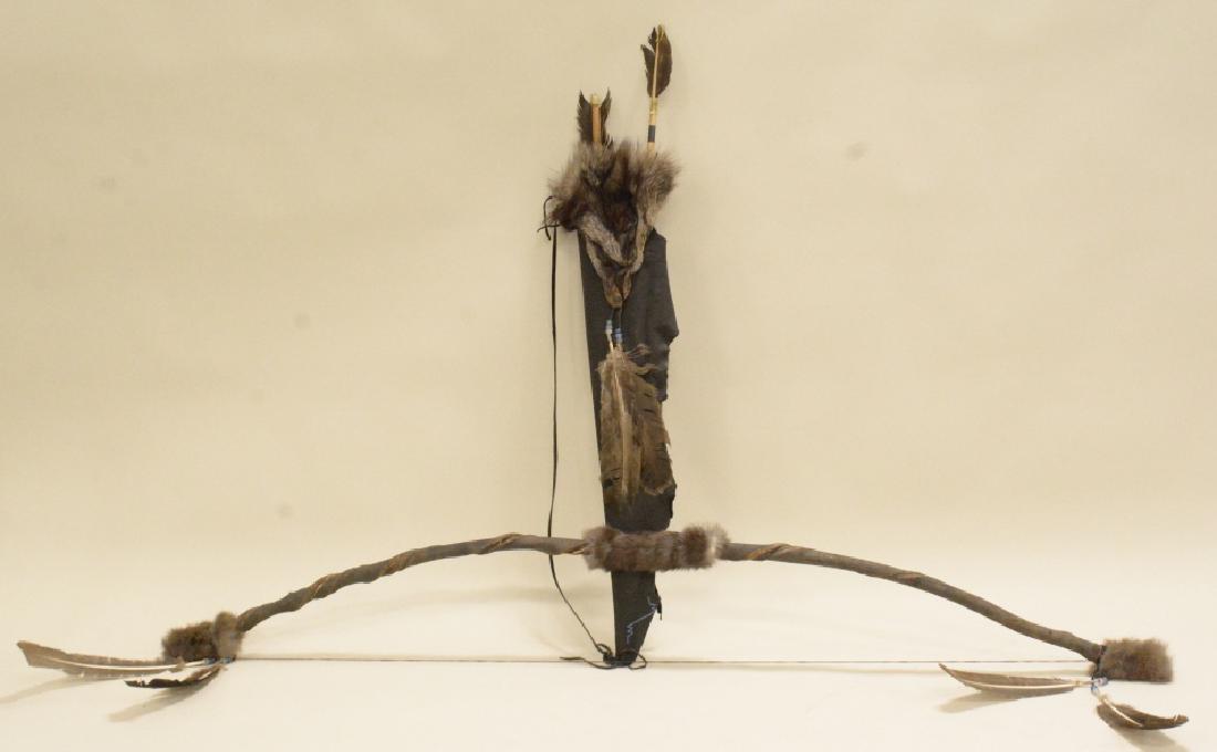 Bow And Arrow With Quiver: Primitive bow and arrow with tanned deer skin leather quiver trimmed with silver fox fur. Two wooden arrows with turkey feather fletching. Bow measures approximately 56".