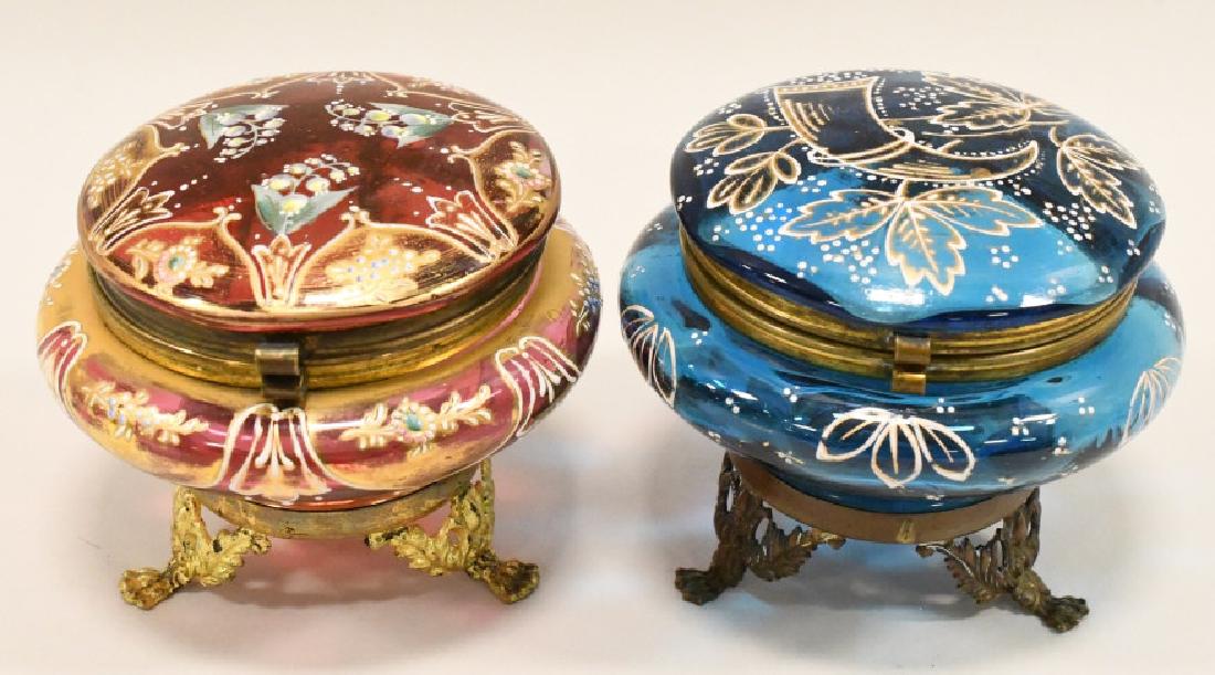 Pair Of Victorian Enamel Painted Dresser Boxes: Beautiful pair of Victorian footed enamel painted colored glass dresser boxes. One is medium blue glass & the other is cranberry. They both stand 3-1/4" tall and have a 4" diameter.