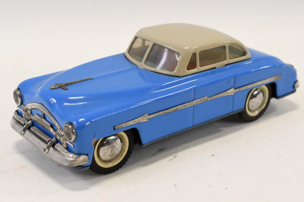 Tin Friction Oldsmobile Car: Nice tin friction Oldsmobile car. Displays nicely with white wall tires. Has light wear from age and display. Measures approximately 10" long.