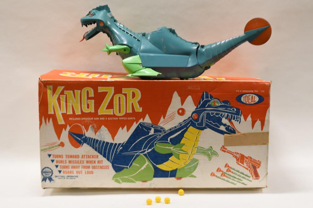Ideal Kingzor Dinosaur Battery Operated: Ideal Toys Kingzor in the original box. Battery operated. Untested. The one foot on the dinosaur is cracked. Has some wear from age and play. Missing the gun and the suction tipped darts. Comes with f