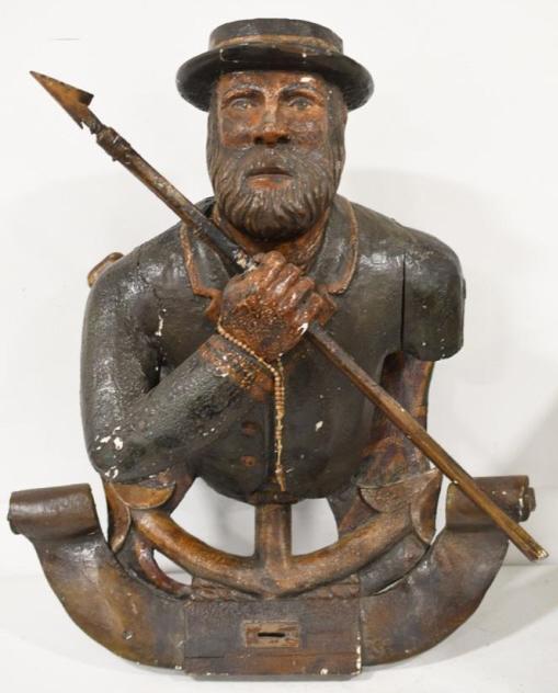 Antique British Maritime Ships Figurehead: Amazing antique British maritime figural ship's figurehead. Figurehead is protruding from an anchor with British flags. The male figurehead is holding a harpoon. At the bottom of the anchor there is a