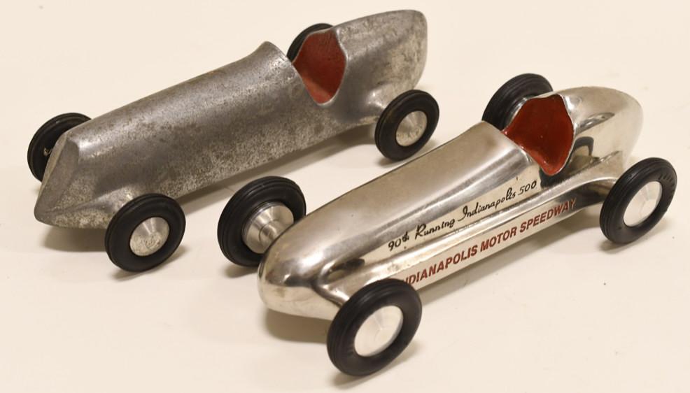 (2) Cast Aluminum Indy Motor Speedway Racer: Nice lot of 2 cast aluminum Indianapolis Motor Speedway racer cars. Nice condition with light wear from use and age. Largest car measures approximately 8 1/2" long.