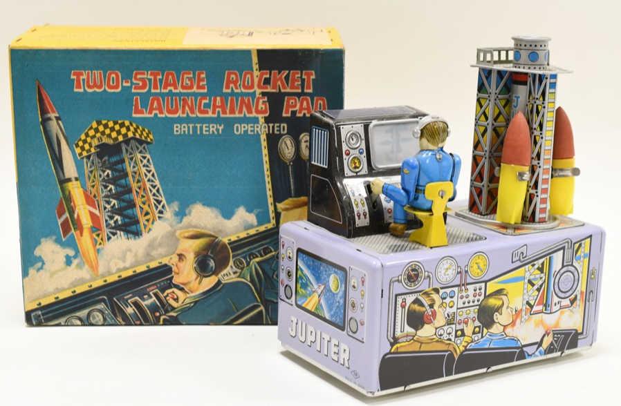 Nomura Tin Battery Op. Two-Stage Rocket Launch Pad: Nice Nomura tin litho battery operated two-stage rocket launching pad. Nice condition with light wear from play and age. Battery compartment is clean. Toy is untested. Box still has the original cardb