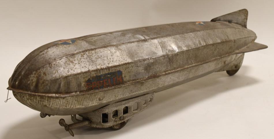 Early Little Giant Zeppelin Pull Toy: Nice pressed steel tin Little Giant Zeppelin pull toy. Displays nicely with dents and dings from age and play. Good condiiton with a nice look. Propellors will move with a little work. Measures approx