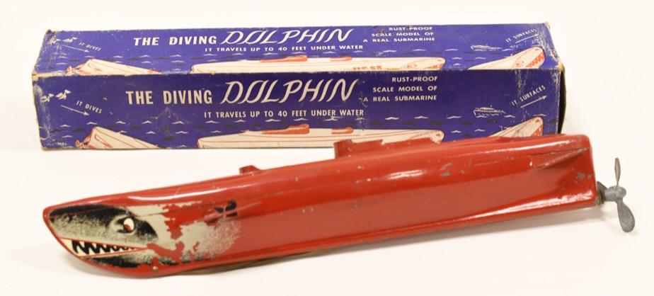 The Diving Dolphin Submarine U.S. 52: Nice vintage pressed metal The Diving Dolphin Submarine U.S. 52 rubber band windup toy. Displays nicely with paint loss and decal wear from age and play. Measures approximately 13 1/2" long.