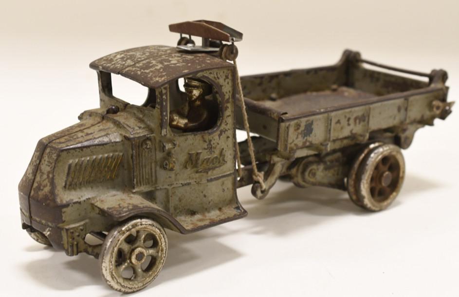 Early Cast Iron Arcade Mack Plunger Dump Truck: Nice early cast iron Arcade Mack dump truck. Has paint loss and wear from age and play. Mack is embossed on both of the doors. The piece connected to the pulleys is not original. Measures approximatel