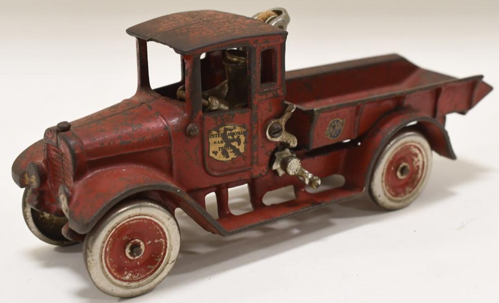 Cast Iron Arcade International Harvester Truck: Nice early cast iron Arcade Red Baby International Harvester dump truck. Arcade is embossed on the inside. Displays nicely with paint loss and wear from play and age. Measures approximately 10 1/2" lo