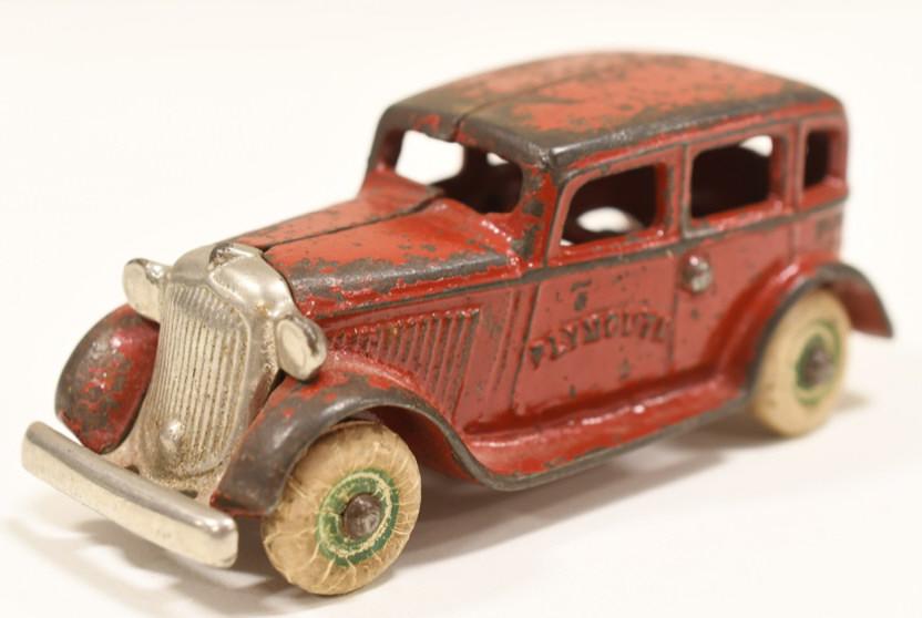 Cast Iron Arcade Plymouth Sedan No.133: Nice early cast iron Arcade Plymouth sedan no. 133. Nice condition with paint loss and wear from use and age. Has one replaced tire. Measures approximately 4-1/2" across.