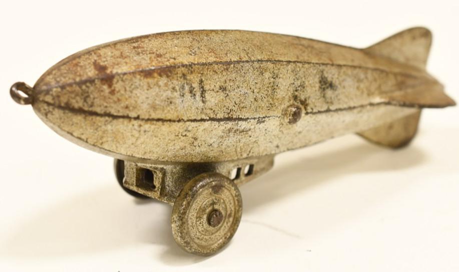 Early Cast Iron Zeppelin Pul Toy w/ Metal Wheels: Early cast iron Zeppelin pull toy with metal wheels. Displays nicely with paint loss and wear from play and age. No markings. Measures approximately 6 1/4" long.