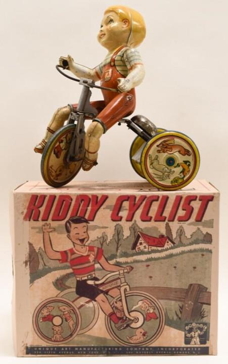Unique Art Tin Litho Windup Kiddy Cyclist: Nice tin litho windup Unique Art Kiddy Cyclist with reproduction box. Displays nicely with wear from age and play. Has paint loss and scratches. Measures approximately 9" tall.