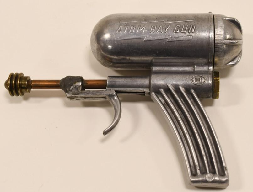 Hiller Atom Ray Squirt Gun: Nice Hiller Atom Ray Gun. Displays nicely with wear from age and play. Measures approximately 6" long.