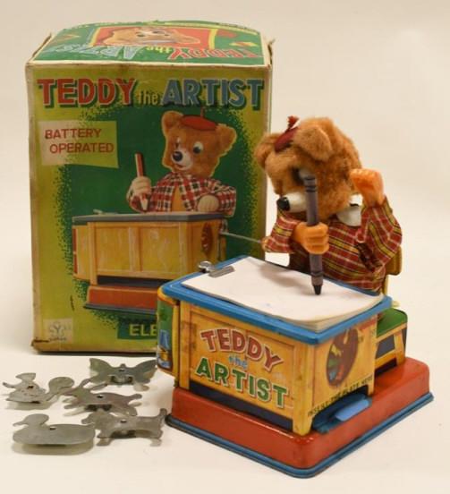 Yonezawa Japan Battery Op. Teddy The Artist: Nice Yonezawa Japan tin battery operated Teddy the Artist with reproduction box. Teddy displays nicely with some paint loss and wear from age. Comes with crayon and templates for the bear. Untested. M