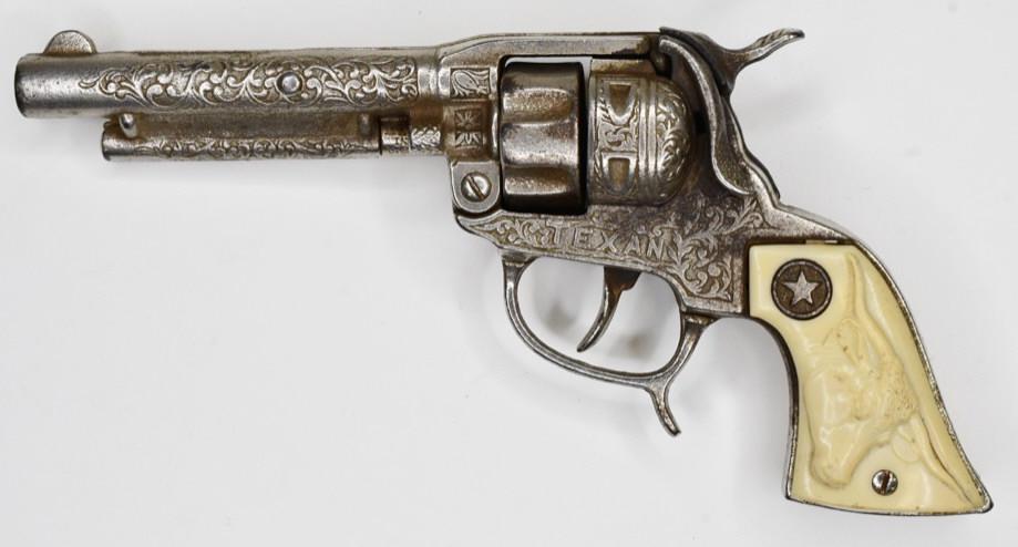 Hubley Texan Cap Gun Pistol: Hubley Texan cap gun pistol. Displays nicely with the longhorn grips. The trigger works. Has wear from play and age. Measures approximately 9 1/4" long.