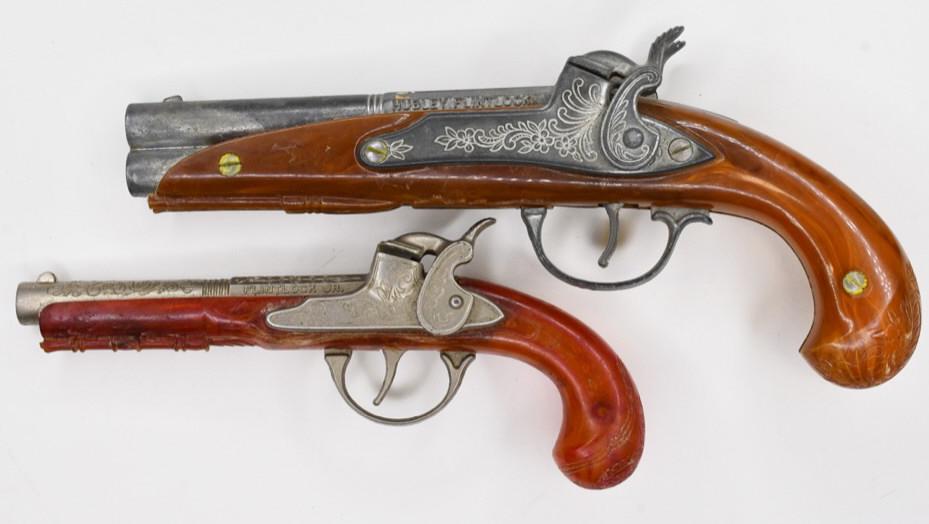 (2) Hubley Flintlock + Flintlock Jr. Cap Guns: Lot of 2 Hubley flintlock and Hubley flintlock jr. cap guns. Both display nicely with wear from play and age. Largest measures approximately 9" across.