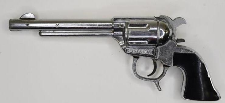 Geo. Schmidt Co. Buck'N Bronco Cap Gun Pistol: Geo Schmidt Co. Buck'N Bronco cap gun with smooth black grips. Displays nicely with wear from use and age. The trigger does not work. Measures approximately 9 1/2" long.