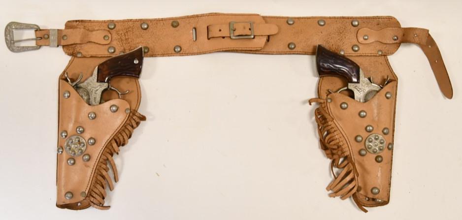 Leslie-Henry Smoky Joe Cap Gun Set: Leslie-Henry Smoky Joe cap gun set with leather holster. The cap guns are in nice condition with some wear from play and age. The triggers work. The holster has wear to the holster. Set displays nicel