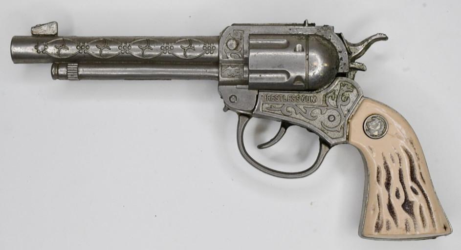 Actoy Restless Gun Cap Gun Pistol: Actoy Restless Gun cap gun pistol. Displays nicely with wear from play and age. The trigger works, but the barrel pops up when the trigger is pulled. Gun measures approximately 9" long.