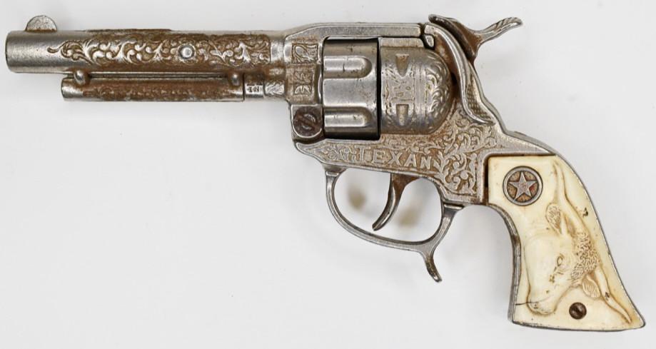 Hubley Texan Cap Gun Pistol: Hubley Texan cap gun pistols. Displays nicely with wear from play and age. The grip has a small crack in it. The trigger works. Measures approximately 8 1/2" long.