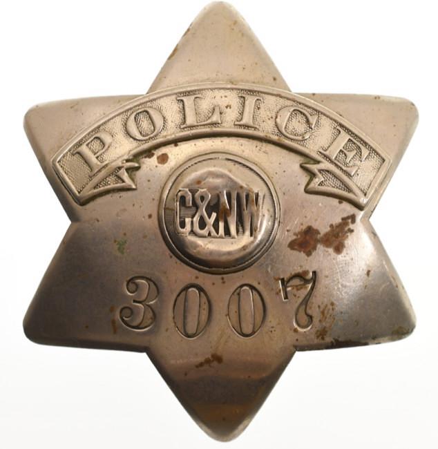 Obsolete C&N.W. Railroad Police Pie Plate Badge: Nice early obsolete Chicago and North Western Railroad Police badge no. 3007. Badge is in good condition with plate loss and wear from use and age. Has pinback. Back is marked " C.H. Hanson Chicago" .
