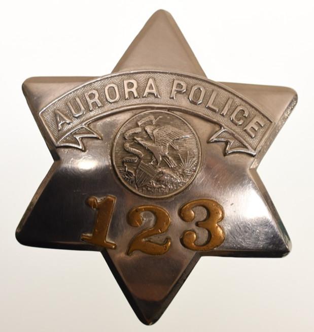 Obsolete Aurora ILL Police Pie Plate Badge No.123: Nice early obsolete Aurora Illinois Police "Pie Plate" badge no. 123 with copper numbers. Badge is in nice condition with wear from use and age. Has pinback. Back is marked "C.H. Hanson Chicago". It m