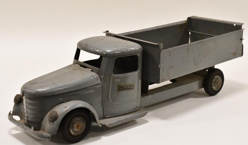 Original Structo Toys Dump Truck: Original Structo Toys dump truck. Displays nicely with paint loss and wear from play and age. The hood opens up and the bed dumps. Measures approximately 21" long.