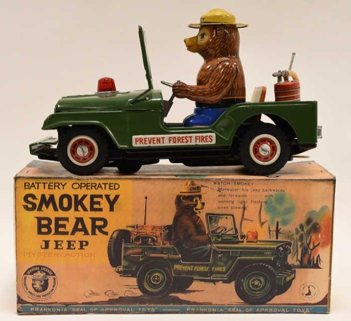 Frankonia Battery Op. Smokey Bear Jeep: Frankonia tin battery operated Smokey Bear Jeep in reproduction box. Displays nicely with wear from age and display. Battery comartment is clean. The toy is untested. The pastic windshield is cracked.