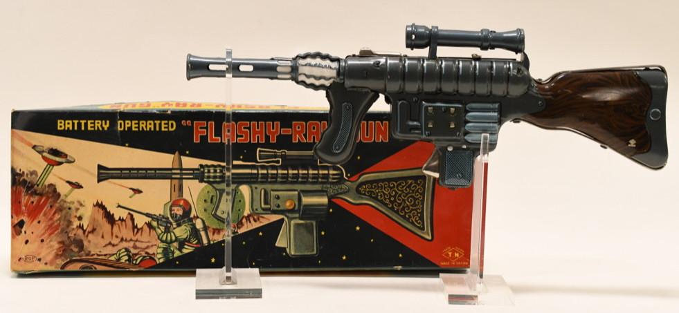 T.N Japan Battery Op. "Flash-Ray" Space Gun: Nice T.N Japan battery operated "Flashy-Ray" space gun with box. Gun displays nicely with light scratches from age. The battery compartment is clean. Box displays nicely with great graphics. Measures