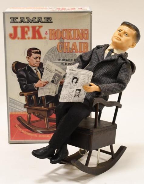 Kamar Windup J.F.K. & Rocking Chair: Nice Kamar windup John F. Kennedy and his rocking chair with reproduction box. Displays nicely with some wear from play and age. Windup mechanism does not work. Measures approximately 11 1/2" tall.