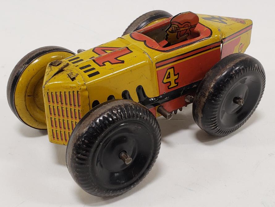 Marx Tin Litho Windup Boat Tail Racer #4: Marx tin litho windup #4 Boat Tail Racer. Car has paint loss and wear from age and play. Displays well with original man. Windup mechanism does not work. Measures approximately 5" long.