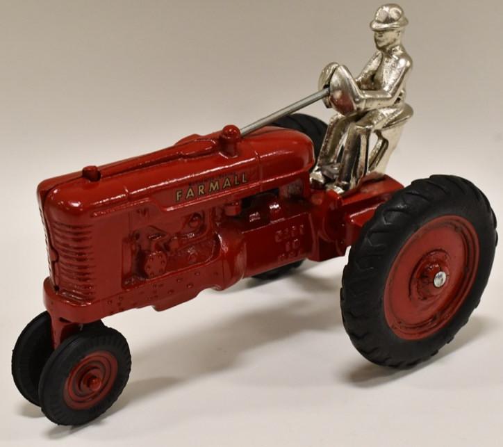 Restored Cast Iron Arcade Farmall M: Restored early cast iron Arcade McCormick-Deering Farmall M tractor with driver. Displays nicely with professional restoration. Measures approximately 7" long.