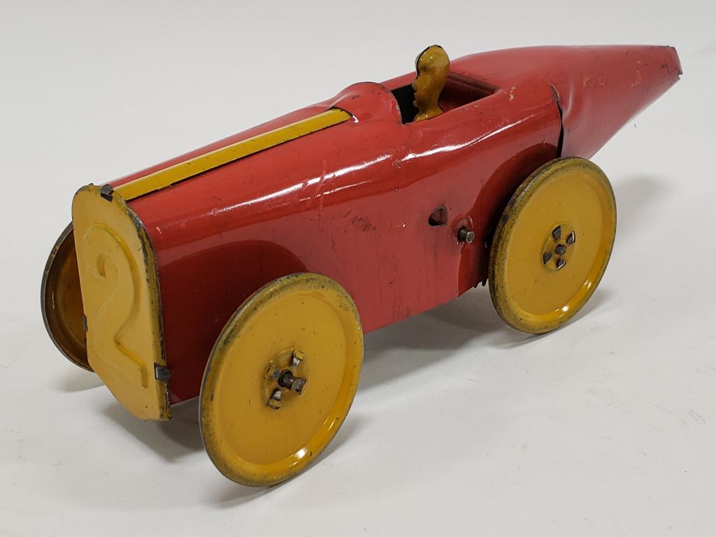 Girard Tin Windup #2 Boat Tail Racer: Girard tin windup #2 boat tail racer with original driver. Nice condition with some paint loss and wear from play and age. Displays nicely. Windup mechanism works. Measures approximately 8" long.