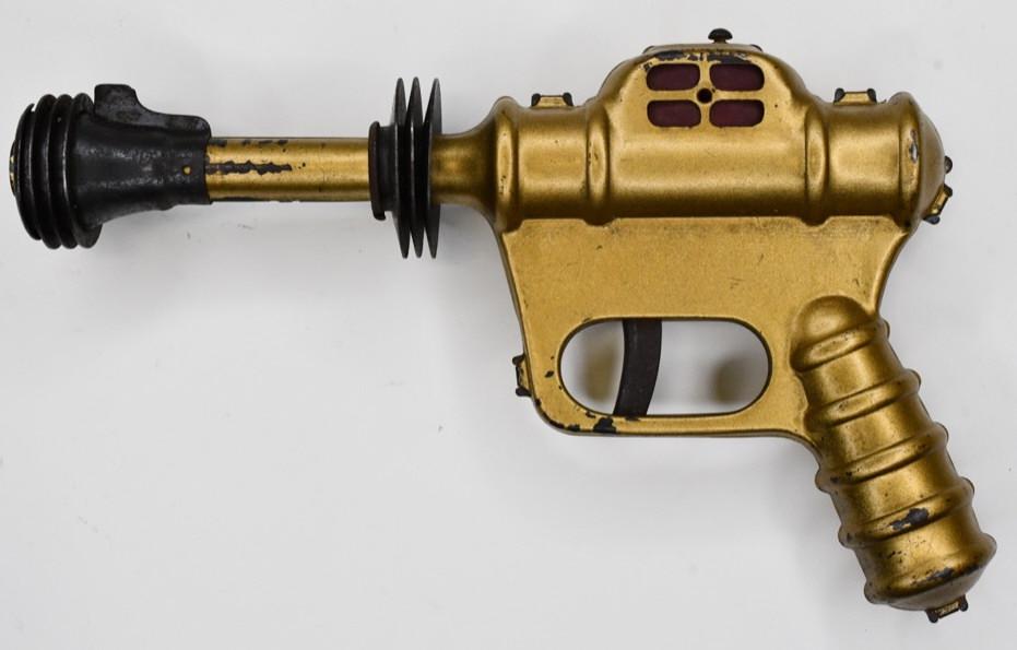 Daisy MFG. Co. Buck Rogers Space Atomic Pistol: Scarce Daisy MFG. Co. Buck Rogers atomic pistol. When the trigger is pulled the gun makes a popping noise and makes a flash in the windows. Displays nicely with a copper finish. Has some wear from use