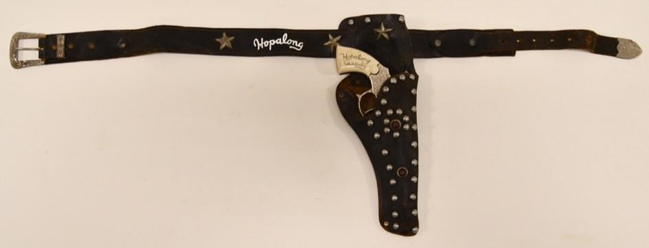 Wyandotte Hopalong Cassidy Single Shot w/ Holster: Wyandotte Hopalong Cassidy single shot cap gun with single holster. The cap gun displays well with wear from age and use. The tigger works. The jeweled leather holster displays well. The Hopalong deca