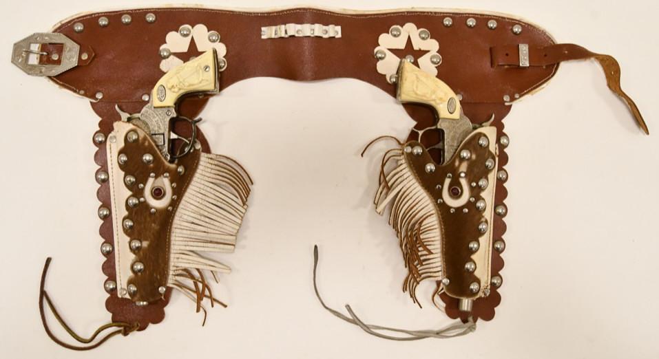 Leslie-Henry Gene Autry 44 Cap Gun Set w/ Holster: Leslie-Henry Gene Autry 44 cap gun set with holster. The one trigger is stuck. Both the guns have wear from play and age. The set displays nicely with a jeweled leather holster.