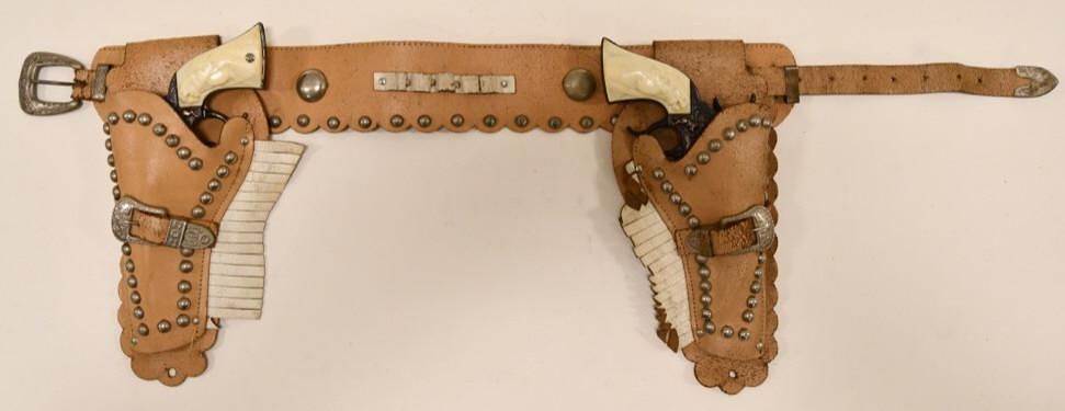 Gene Autry Cap Gun Set with Holster: Nice set of Gene Autry cap guns with leather holster. The cap guns display well with some wear from age and use. Both triggers work. The leather holster has some wear from age. Overall the set display