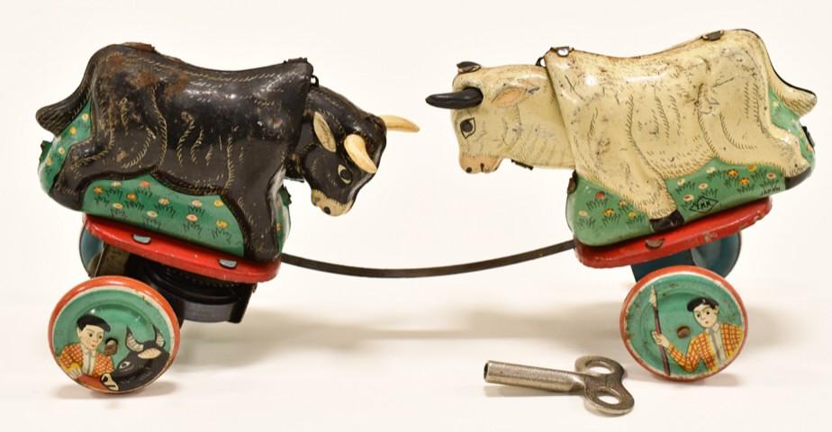 Japan TKK Tin Litho Windup Fighting Bulls: Japan TKK tin litho windup fighing bulls. The windup mechanism works. The bulls rush each other and then butt heads. Displays nicely with paint loss and wear from play and age. Measures approximately 