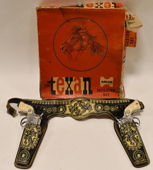 Halco The Texan Holster Set with Cap Guns: Halco The Texan holster set with cap guns. The set includes (2) Texas cap guns made by Long Island Die-Casting Inc and a leather holster. The box has wear and tear from age. The triggers work. Overall