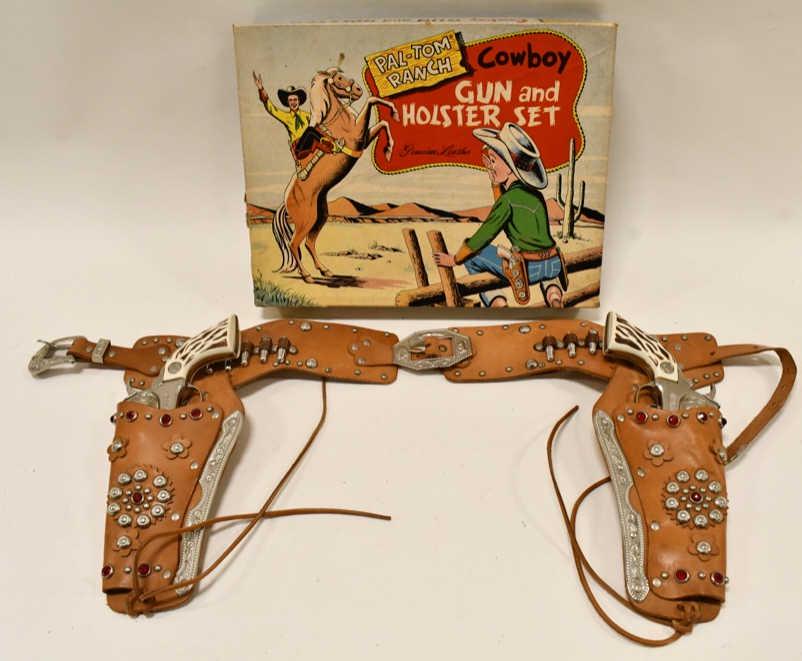 Pal-Tom Ranch Cowboy Cap Gun and Holster Set: Pal-Tom Ranch Cowboy cap gun and holster set in the box. The set comes with (2) Hubley Marshal cap guns and a double leather holster. The box has some wear around the edges. Displays nicely with good