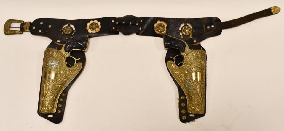 Gold Leslie-Henry Champion Cap Gun Set w/ Holster: Gold Leslie-Henry Champion cap gun set with holster. The cap guns have some corrosin and wear from age. Both triggers work. The leather holster is in nice condition with some wear to the leather. Over