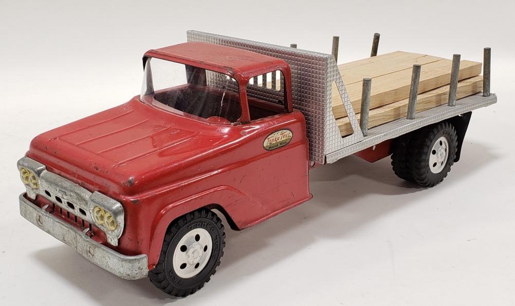 Tonka Stake Lumber Truck: Original square fender Tonka stake bed lumber truck. Displays nicely with some light paint loss and wear from play and age. Measures approximately 17" across.