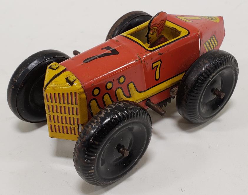 Marx Tin Litho Windup Boat Tail Racer #7: Marx tin litho windup #7 Boat Tail Racer. Car has light paint loss and wear from play and age. The windup mechanism works. Measures approximately 5" long.