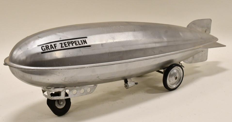 Restored Steelcraft Graf Zeppelin Pull Toy: Restored Steelcraft Graf Zeppelin pull toy. The front tire is broke. Displays nicely with an amateur restoration. Measures approximately 30" long.