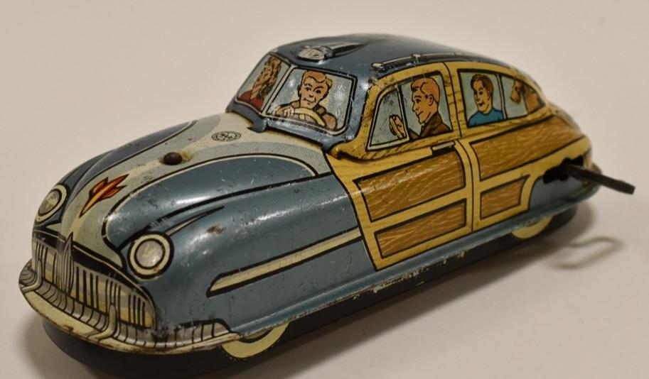 Marx Tin Litho Windup Woody Station Wagon: Marx tin litho windup Woody station wagon. Displays nicely with family pictured in the window. Liscence plate reads LM52. Nice condition with some paint loss and wear from play and age. Measures appro
