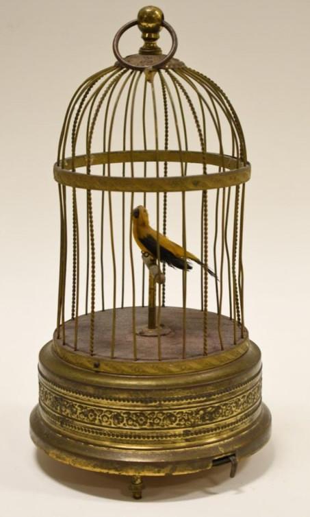 Vintage Singing Bird In Cage Automaton Music Box: Vintage German singing bird in cage automaton music box. Has wind-up movement. When wound the bird sings, beak moves, and head turns back and forth. Measures approximately 10" tall with a 6-1/2" botto