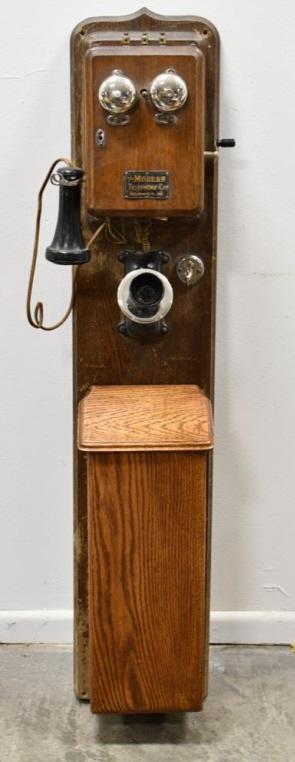 Early Modern Telephone Co Oak Wall Mount Telephone: Early Modern Telephone Co. oak wall mount telephone. Good condition with some scratches and chips to the oak cabinet . Displays very well with double bells, and removable shelf. Magneto is present. Mi