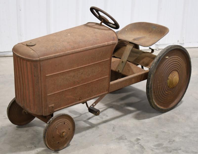 Early Graham-Bradley Pedal Tractor: Early Graham-Bradley pedal tractor. The pedal tractor has paint loss and wear from play and age. Displays well with great patina. Measures approximately 43" long.