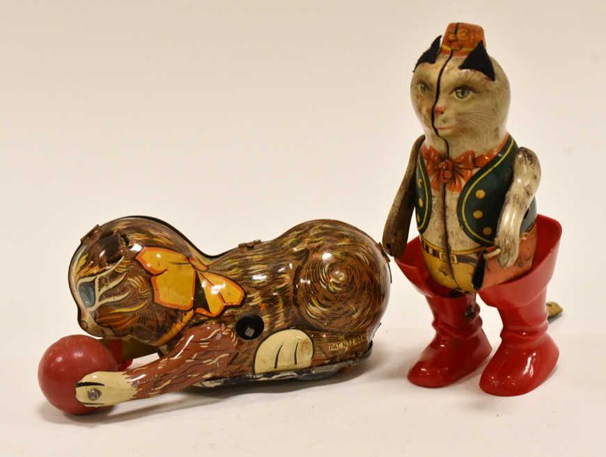 (2) German & Marx Tin Litho Windup Cats: Includes a German tin litho windup puss n boots and a Marx playful cat. The Marx cat is missing its ears and tail. Both are missing the keys. Measures approximately 5" long.