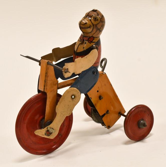 Early Tin Litho Windup Monkey Riding a Tricycle: Early tin litho windup monkey riding a tricycle. The windup does not work. Has some paint loss and wear from age. Measures approximately 6" tall.