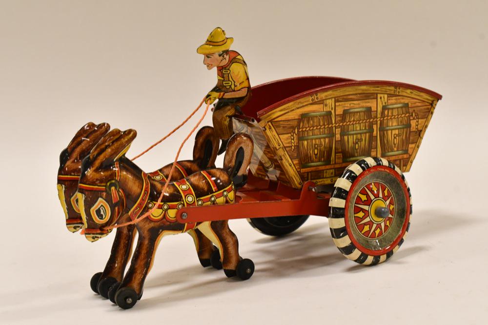 Marx Tin Litho Windup Donkey Team & Cart: Marx tin litho windup donkey team and cart. Displays well with good graphics and light wear from play and age. Windup mechanism works. Measures approximately 10" long.
