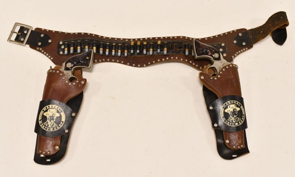 Hubley Wyatt Earp Cap Gun Set + Wyatt Earp Holster: Hubley Wyatt Earp cap gun set with Marshal Wyatt Earp leather holster. The cap guns have some corrosion and tarnish from sitting in the holsters. Both triggers work. The holster has some cracking and 